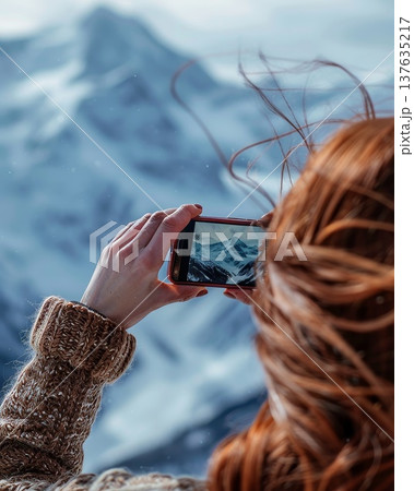 Woman Capturing Majestic Mountain Landscape with a Camera Under Bright Blue Skies and Soft, Golden Sunlight Woman Capturing Majestic Mountain Landscape with a Camera Under Bright Blue Skies and Soft, Golden Sunlight 137635217