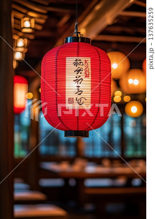 Elegant red lantern casting a warm glow in a cozy restaurant dining space, inviting ambiance for guests. 137635259