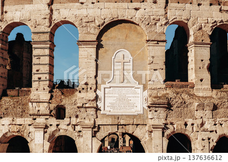 Historic Roman architecture shows the Colosseum in sunlight with visitors exploring 137636612