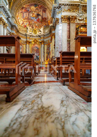 Views of wooden benches and marble floor in a large church with high ceiling and artwork Views of wooden benches and marble floor in a large church with high ceiling and artwork 137636768