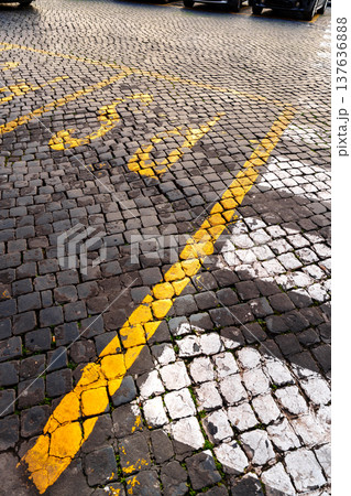 Parking lot with yellow and white lines on cobblestone surface in an urban area 137636888