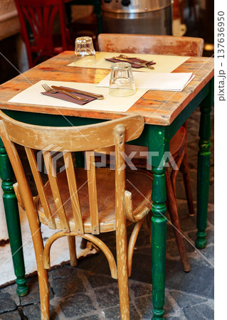 Table and chairs set for dining at a restaurant in a busy area during the day 137636950