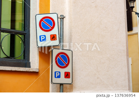 Parking signs on a street corner in a city with yellow walls during daylight hours Parking signs on a street corner in a city with yellow walls during daylight hours 137636954