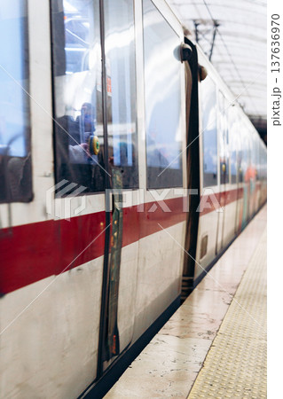 Train stops at platform for passengers to board and disembark during busy travel time 137636970