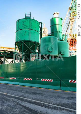 Construction site showing green equipment and machinery near a city street in bright weather Construction site showing green equipment and machinery near a city street in bright weather 137637014