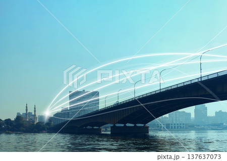 Bridge connects two sides of the river with light trails showing movement above the water 137637073