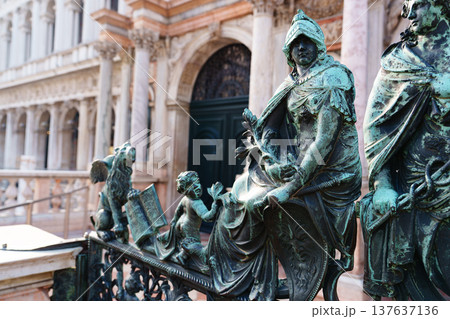 Bronze statues on a railing near an old building in Venice during daylight hours 137637136