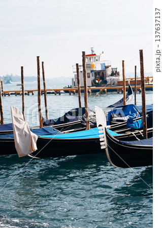 Boats sit in water near a dock as a boat arrives in the distance Boats sit in water near a dock as a boat arrives in the distance 137637137