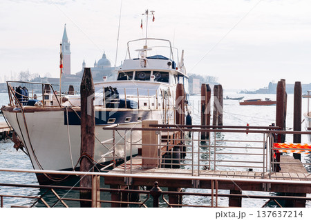 Boat docked at waterfront with buildings in the background during daytime in a coastal area Boat docked at waterfront with buildings in the background during daytime in a coastal area 137637214
