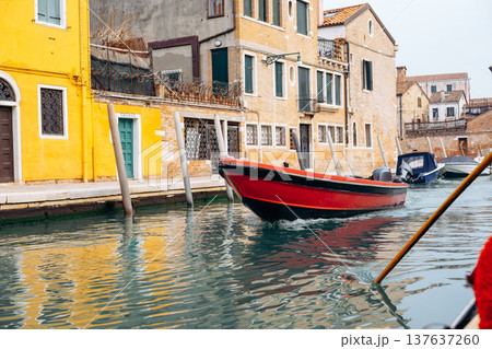 Boat moves through a canal in a historic city during a quiet day of exploration 137637260