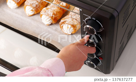 Person using oven to bake pastries during daytime in a kitchen Person using oven to bake pastries during daytime in a kitchen 137637277