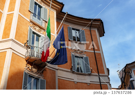 Italian flag and European Union flag wave from building balcony in Rome Italian flag and European Union flag wave from building balcony in Rome 137637286