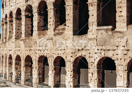 Colosseum stands in Rome during a clear day with tourists around and history in the air Colosseum stands in Rome during a clear day with tourists around and history in the air 137637293