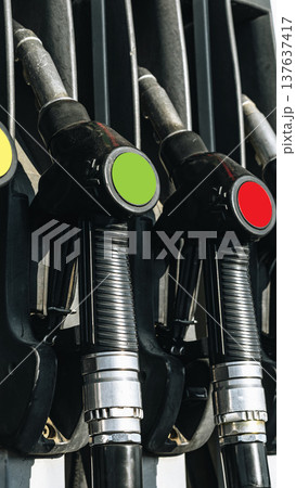 Different fuel dispensers lined up at a gas station showing various colors and types 137637417