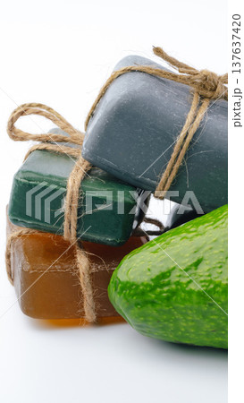 Three soap bars and a cucumber on white surface with tied string Three soap bars and a cucumber on white surface with tied string 137637420