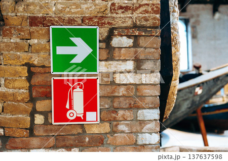 Signs showing the way and fire safety in an old building by the water 137637598
