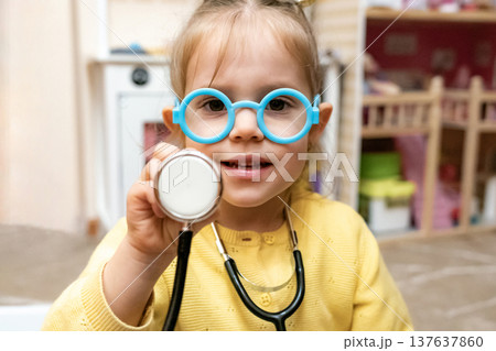 Toddler girl open mouth laugh stethoscope glasses raised hand Toddler girl open mouth laugh stethoscope glasses raised hand 137637860