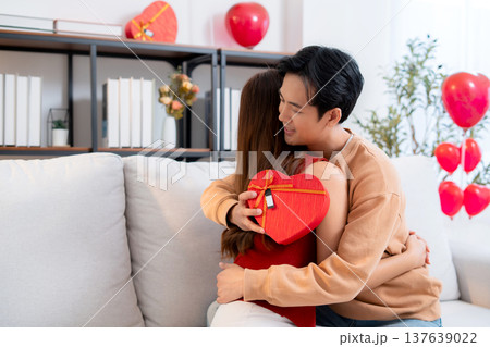 Happy asian couple embracing with love after receiving heart gift box. 137639022