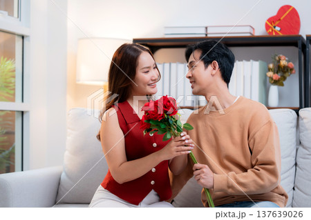 Happy asian woman receiving rose bouquet from boyfriend with celebrating Valentine's Day. Happy asian woman receiving rose bouquet from boyfriend with celebrating Valentine's Day. 137639026