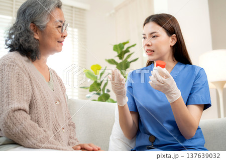 Asian woman nurse explaining medicine instruction to senior patient. 137639032