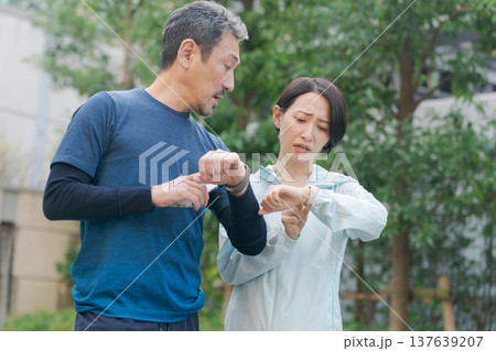 時計を見て困るアクティブな夫婦 時計を見て困るアクティブな夫婦 137639207