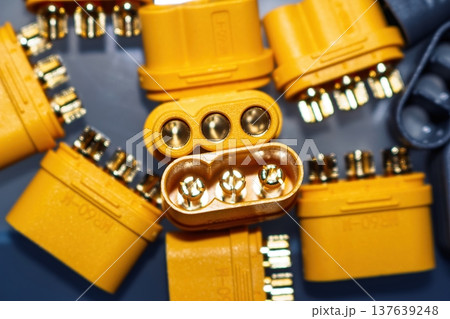 Macro shot of bright yellow MR60 power plugs, male and female, featuring gleaming gold-plated brass pins for electric motors and e-transport systems Macro shot of bright yellow MR60 power plugs, male and female, featuring gleaming gold-plated brass pins for electric motors and e-transport systems 137639248