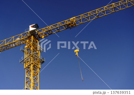 Tower Crane Operating on an Active Urban Construction Site. High quality photo Tower Crane Operating on an Active Urban Construction Site. High quality photo 137639351