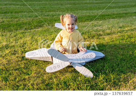 Flying girl. Yellow cardboard costume child. Park activity sunshine toddler. Flying girl. Yellow cardboard costume child. Park activity sunshine toddler. 137639657