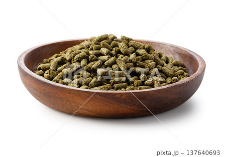 白背景に置かれた木製ボウル入りのウサギの餌（ペレット） 137640693