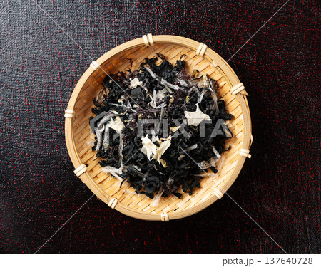 黒背景に置かれた竹ざる入りの乾燥海藻サラダ（真俯瞰） 137640728