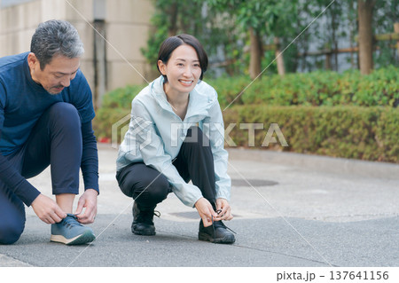 靴紐を結ぶアクティブな夫婦 靴紐を結ぶアクティブな夫婦 137641156