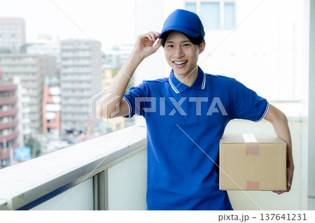 荷物を届ける宅配便の若い男性　 137641231