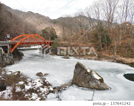 冬の凍結した王滝川の川面と赤い色の常盤橋 冬の凍結した王滝川の川面と赤い色の常盤橋 137641242
