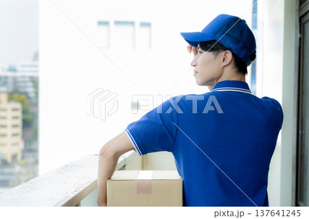 荷物を届ける宅配便の若い男性 荷物を届ける宅配便の若い男性 137641245