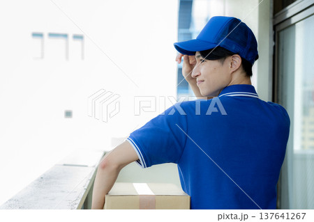 荷物を届ける宅配便の若い男性　 137641267