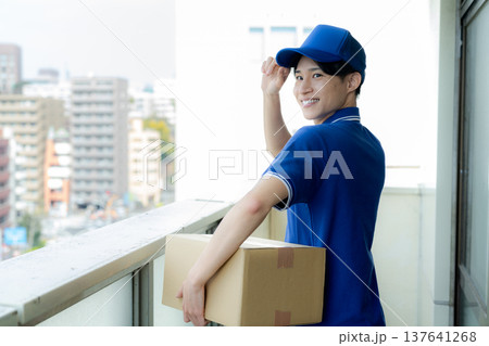 荷物を届ける宅配便の若い男性　 137641268