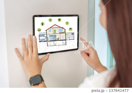 Smart Home Management. Woman using tablet to control home features. 137641477