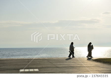 陽が傾き始めたころ片瀬西浜海岸デッキから海を眺める人たち 137643335