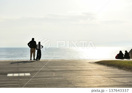陽が傾き始めたころ片瀬西浜海岸デッキから海を眺める人たち 137643337