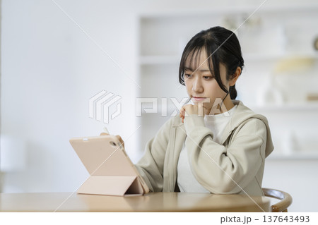 タブレットを使って勉強する大学生 137643493