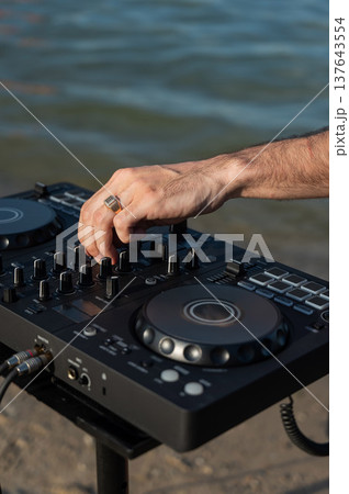 Close up of DJ's hands while working outdoors.  137643554