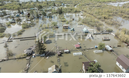 Spring flood disaster with fully submerged houses, flooded roads and overflowing waterways. The footage shows the dramatic impact of heavy rainfall and rising water levels on residential areas 137643602