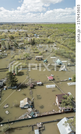 Spring flood disaster with fully submerged houses, flooded roads and overflowing waterways. The footage shows the dramatic impact of heavy rainfall and rising water levels on residential areas 137643603