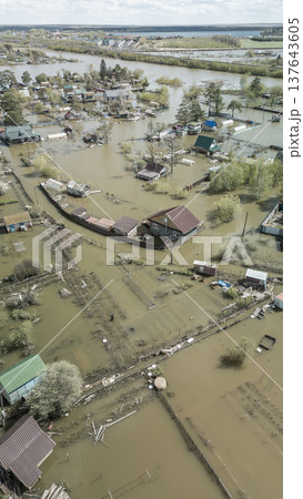 Spring flood disaster with fully submerged houses, flooded roads and overflowing waterways. The footage shows the dramatic impact of heavy rainfall and rising water levels on residential areas Spring flood disaster with fully submerged houses, flooded roads and overflowing waterways. The footage shows the dramatic impact of heavy rainfall and rising water levels on residential areas 137643605