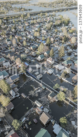 Spring flood disaster with fully submerged houses, flooded roads and overflowing waterways. The footage shows the dramatic impact of heavy rainfall and rising water levels on residential areas 137643609