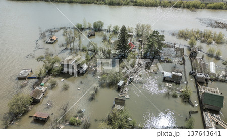 Spring flood disaster with fully submerged houses, flooded roads and overflowing waterways. The footage shows the dramatic impact of heavy rainfall and rising water levels on residential areas 137643641