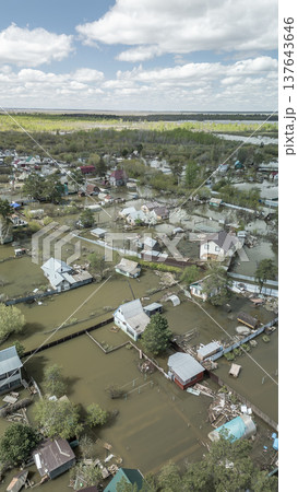 Spring flood disaster with fully submerged houses, flooded roads and overflowing waterways. The footage shows the dramatic impact of heavy rainfall and rising water levels on residential areas 137643646