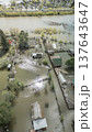 Spring flood disaster with fully submerged houses, flooded roads and overflowing waterways. The footage shows the dramatic impact of heavy rainfall and rising water levels on residential areas 137643647