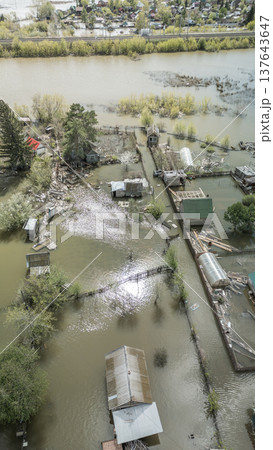 Spring flood disaster with fully submerged houses, flooded roads and overflowing waterways. The footage shows the dramatic impact of heavy rainfall and rising water levels on residential areas Spring flood disaster with fully submerged houses, flooded roads and overflowing waterways. The footage shows the dramatic impact of heavy rainfall and rising water levels on residential areas 137643647