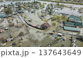 Spring flood disaster with fully submerged houses, flooded roads and overflowing waterways. The footage shows the dramatic impact of heavy rainfall and rising water levels on residential areas 137643649